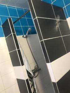 łazienka z prysznicem wyłożonym czarno-białymi kafelkami w obiekcie FM Hotel w Paryżu