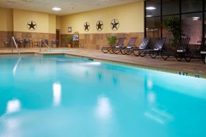 a swimming pool with blue water in a building at Holiday Inn Hotel and Suites Beaumont-Plaza I-10 & Walden, an IHG Hotel in Beaumont