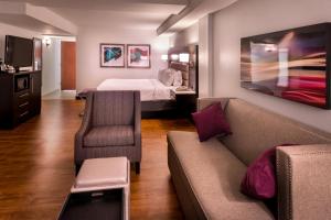 a hotel room with a couch and a bed at Holiday Inn Hotel and Suites Beaumont-Plaza I-10 & Walden by IHG in Beaumont
