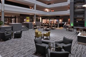 eine Lobby eines Hotels mit Stühlen und Tischen in der Unterkunft Holiday Inn Hotel and Suites Beaumont-Plaza I-10 & Walden, an IHG Hotel in Beaumont