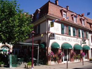 a building on the corner of a street at Hôtel Bar Des Vosges in Munster