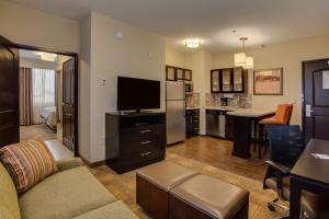 アトランタにあるStaybridge Suites Atlanta Airportのリビングルーム(ソファ、テレビ付)、キッチン