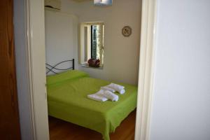 a bedroom with a green bed with towels on it at Afissos View in Afissos