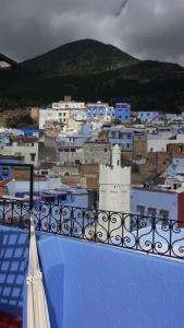 un balcone con vista sulla città e sugli edifici blu e bianchi di AYMANE ROOFTOP budget panoramic HOTEL a Chefchaouen