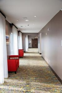 a hallway with a red couch and curtains in a hospital at Holiday Inn & Suites - Savannah Airport - Pooler, an IHG Hotel in Savannah