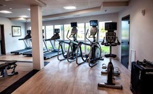 a gym with several tread machines and a camera at Holiday Inn & Suites - Savannah Airport - Pooler, an IHG Hotel in Savannah