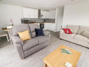 a living room with two couches and a table at Beechnut Cottage in Tewkesbury