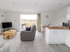 a kitchen and living room with two chairs and a table at Beechnut Cottage in Tewkesbury