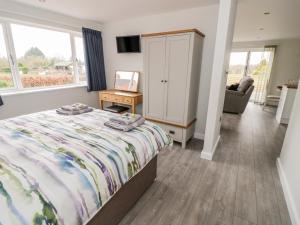 a bedroom with a bed and a chair and a desk at Beechnut Cottage in Tewkesbury