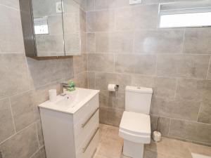 a bathroom with a white toilet and a sink at Beechnut Cottage in Tewkesbury +18 photos