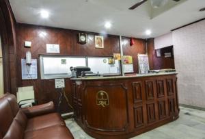 - un bar dans un salon de coiffure avec canapé en cuir dans l'établissement Hotel Maya Deluxe, à Hyderabad