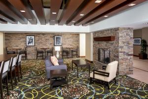 a lobby with a fireplace and chairs and tables at Staybridge Suites Atlanta - Midtown by IHG in Atlanta