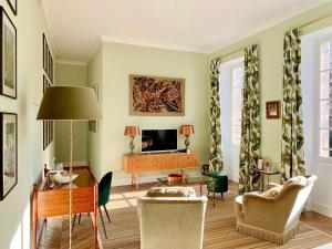 a living room with a television and a table and chairs at Le Clos Saluces in Avignon