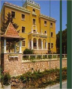 a large yellow building on top of a stone wall at Hotel Paradiso in Monteluco