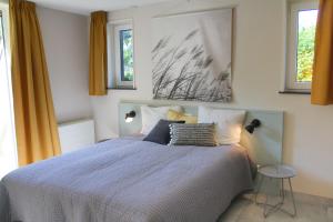 een slaapkamer met een bed en twee ramen bij Sandy 36 in Callantsoog