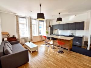 een woonkamer met een bank en een keuken bij Brivibas Center Apartments in Rīga