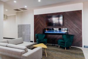 梅薩的住宿－Holiday Inn & Suites Phoenix-Mesa-Chandler, an IHG Hotel，客厅配有沙发、椅子和电视