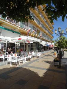 a group of tables and chairs in front of a building at Hotel Torremolinos Centro in Torremolinos