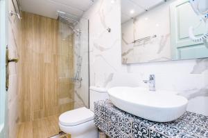 a white bathroom with a sink and a toilet at Alegria Pension in Chania Town