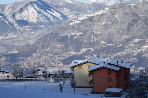 a house in the snow in front of a mountain at Cà Nosent in Pisogne