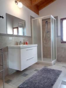 bagno con lavandino bianco e doccia di Cà Nosent a Pisogne