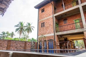 a brick building with a blue door and a fence at Negombo Boutique Villa in Negombo