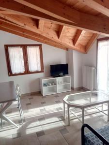 a living room with a glass table and a tv at Cà Nosent in Pisogne