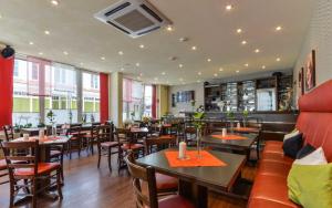 - un restaurant avec des tables et des chaises dans une salle dans l'établissement Hotel Kirchhainer Hof, à Kirchhain