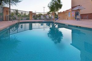 ein Pool mit blauem Wasser in einem Gebäude in der Unterkunft Holiday Inn & Suites Goodyear - West Phoenix Area, an IHG Hotel in Goodyear