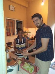 a man and woman standing in a kitchen preparing food at Milan Home Stay in Ella +20 photos