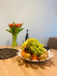 un plato de fruta en una mesa con una botella de vino en Apartament Bankowa en Jelenia Góra