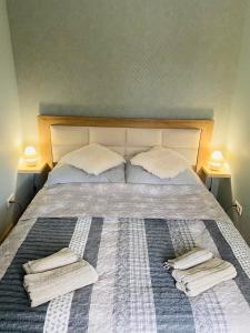 1 cama con 2 almohadas y toallas en Apartament Bankowa en Jelenia Góra