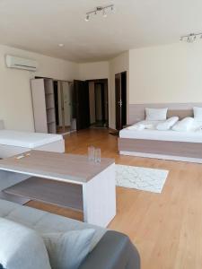 a living room with two beds and a table at Hotel Lago Peshtera in Peshtera