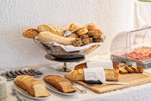 a table topped with a bowl of bread and pastries at Hotel San Giorgio Terme in Ischia