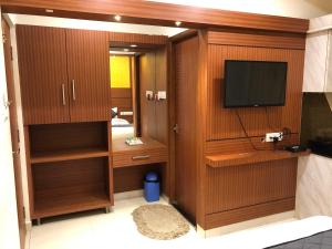 チェンナイにあるHOTEL SPARK RESIDENCYのテレビ、木製キャビネットが備わる客室です。