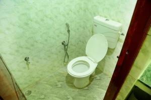 ZuriEL Suite GUEST HOUSE في كويمباتور: حمام مع مرحاض أبيض في الغرفة