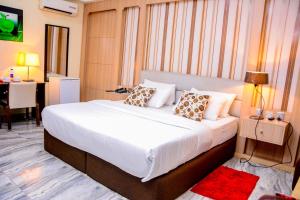 ein Schlafzimmer mit einem großen weißen Bett mit Kissen in der Unterkunft GolfView Suites & Conference Center in Ikeja