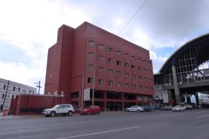 a red building with cars parked in front of a street at Hotel Son- Mar Monterrey Centro in Monterrey