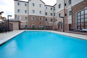a large blue swimming pool in front of a building at Staybridge Suites San Antonio Sea World by IHG in San Antonio