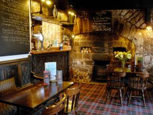 a restaurant with a table and chairs and a fireplace at Old Court Hotel & Apartments in Symonds Yat