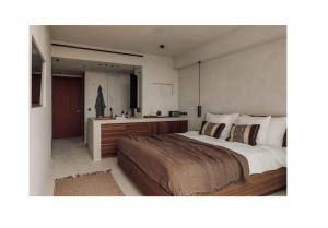 a bedroom with a large bed and a bathroom at OKU Ibiza in San Antonio