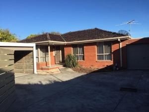 a brick house with a garage and a driveway at Budget Clayton Homestay in Clayton North