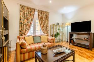 a living room with a couch and a tv at Lisbon Stay at Roma Boulevard in Lisbon