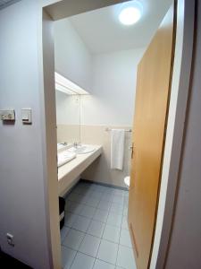 uma casa de banho com um lavatório, um WC e um espelho. em CEU Konferencia Központ em Budapeste