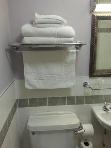 a bathroom with a toilet and towels on a shelf at Punch House Monmouth in Monmouth