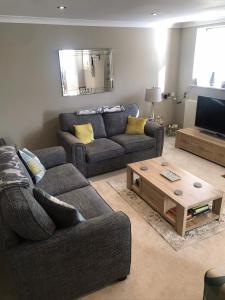 a living room with two couches and a coffee table at Harlow Coach House in Harrogate