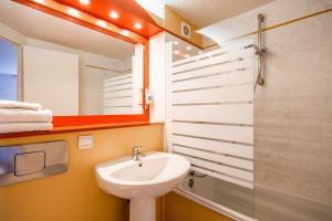 a bathroom with a sink and a mirror and a shower at Comfort Hotel Montlucon in Montluçon +10 photos