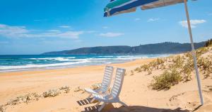 a beach chair and an umbrella on a beach at Shan C in Wilderness