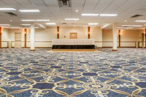 um quarto grande com uma mesa no meio em Econo Lodge Broken Arrow-Tulsa em Broken Arrow