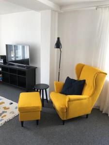 マルヒョーにある"Über den Dächern"のリビングルーム(黄色い椅子、テレビ付)